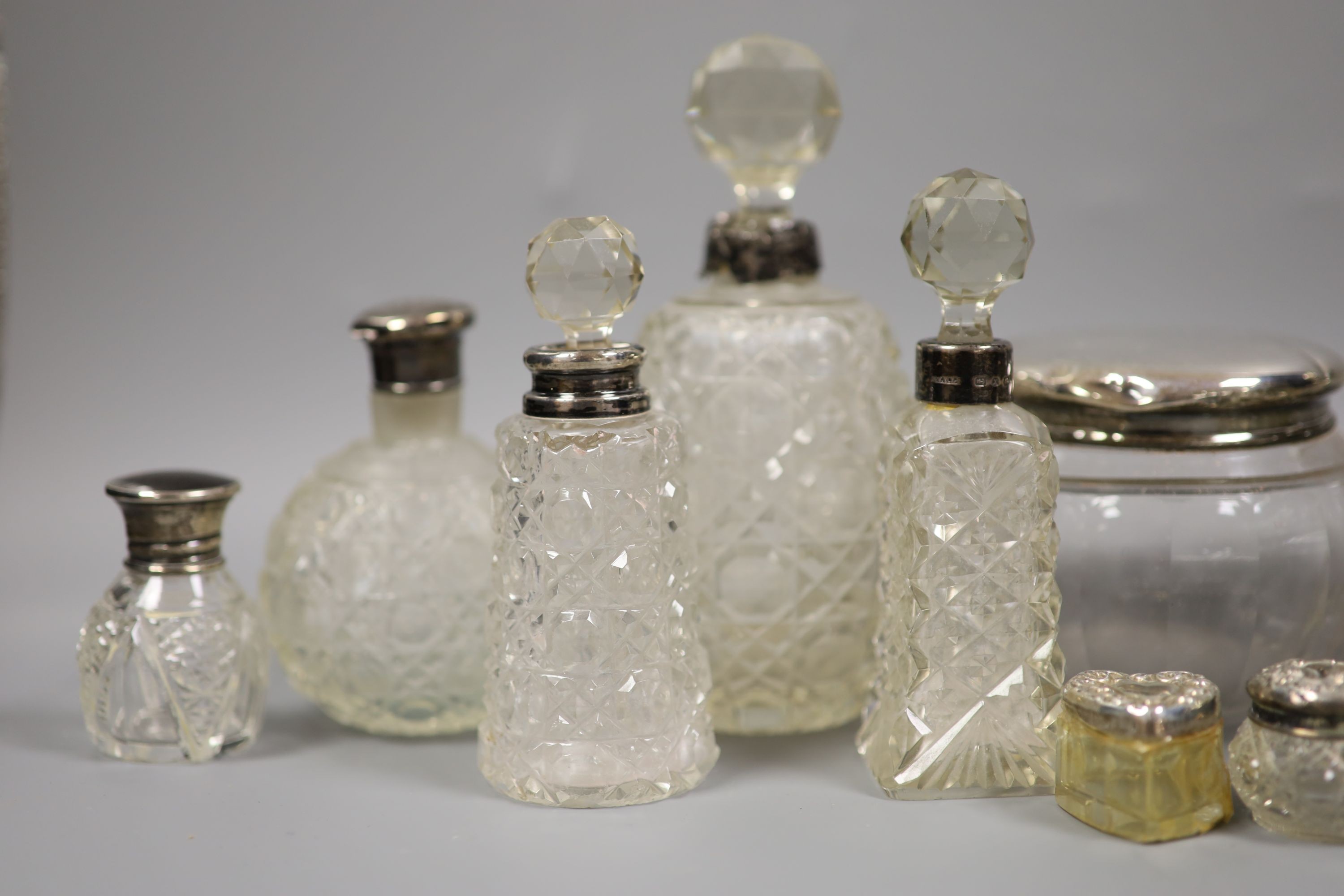 A collection of assorted silver mounted glass scent bottles, toilet jars etc. (a.f.)